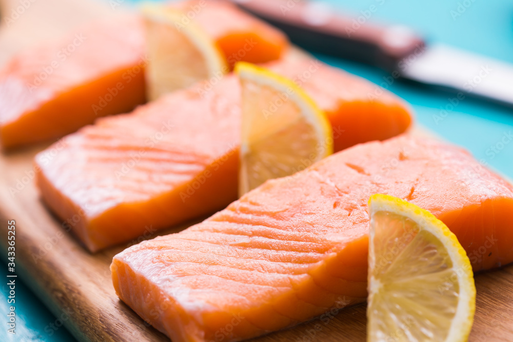 Delicious salmon steak on wooden cutting board, close-up.