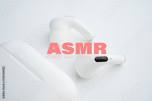 Autonomous sensory meridian response, ASMR text. Earphones to hear sound waves as a symbol of enjoying sounds, whisper or music. photo