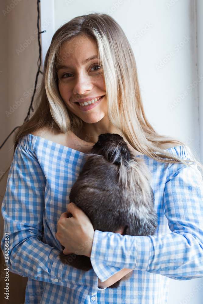 Pet and Easter concept - Happy girl hugging brown rabbit at home. Pet and Easter concept - Happy girl hugging brown rabbit at home.