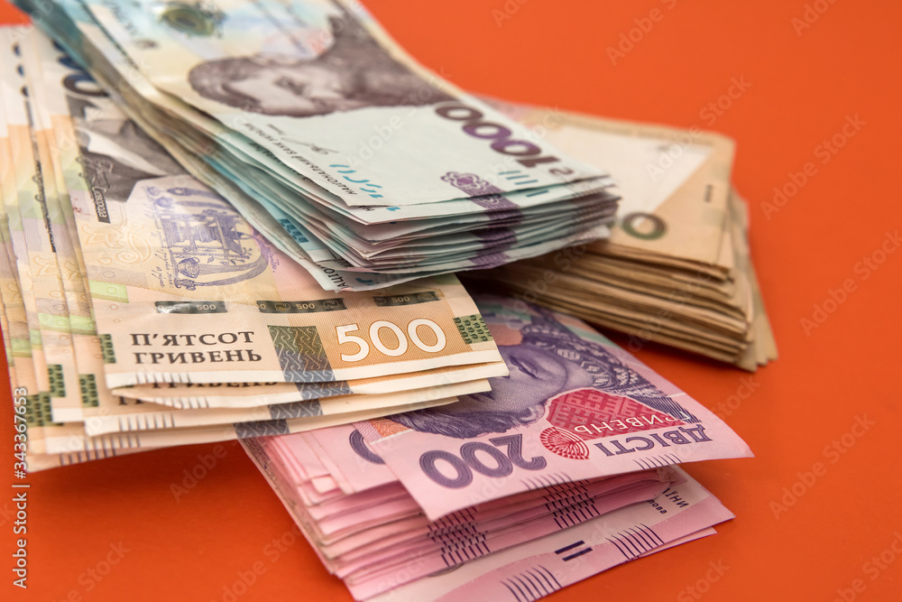 bundle of Ukrainian money isolated on red, stack of hryvnia uah, 200 500 and new 1000 banknote bundle of Ukrainian money isolated on red, stack of hryvnia uah, 200 500 and new 1000 banknote
