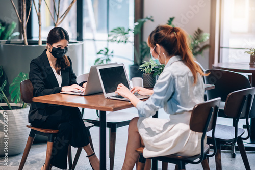 Group of Asian People Successful Teamwork Businesswoman Wearing Medical Mask and Working with Laptop. Work from Private Home Office Social Distancing among Coronavirus Outbreak Situation