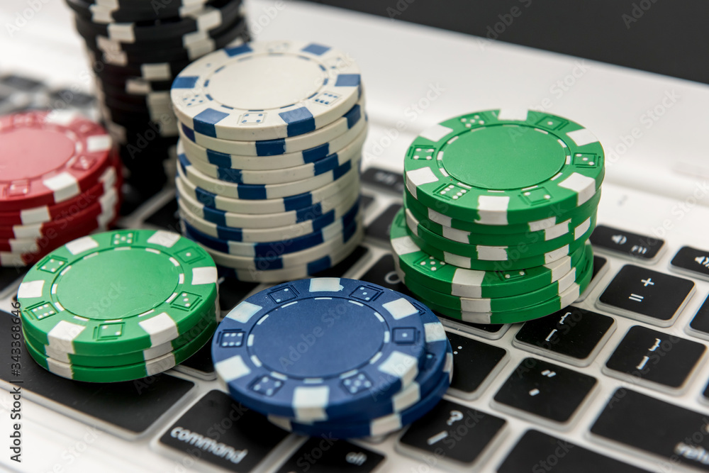 Different of cost casino chips stacking on a laptop. Gabmling Different of cost casino chips stacking on a laptop. Gabmling