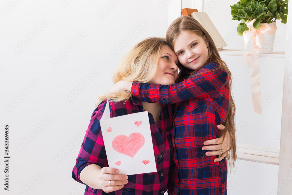 Mother's Day, holidays and family holidays - Mother holds greeting card from her lovely daughter. Mother's Day, holidays and family holidays - Mother holds greeting card from her lovely daughter.