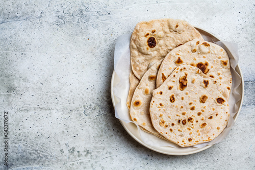 Homemade indian flatbread chapati on a gray background. Vegetarian cuisine concept. photo