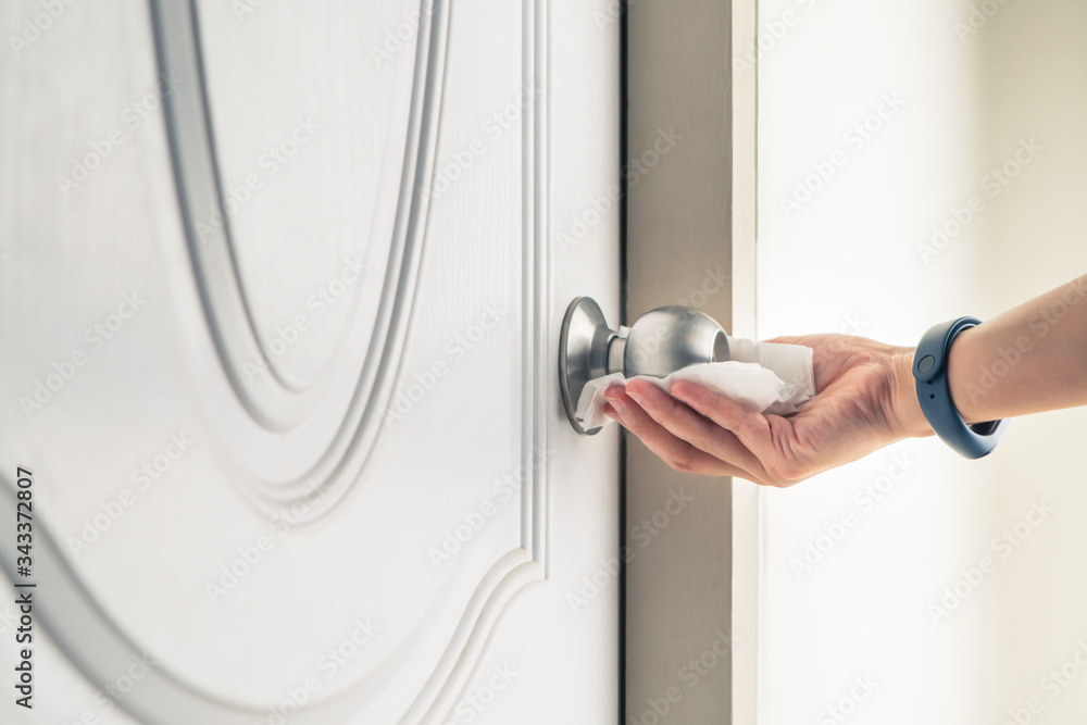 Cleaning door knob with alcohol spray for Covid-19 Coronavirus prevention Cleaning door knob with alcohol spray for Covid-19 Coronavirus prevention