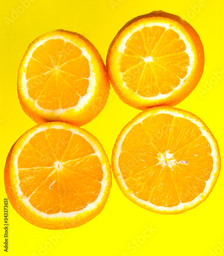 Orange slices on a yellow background close-up