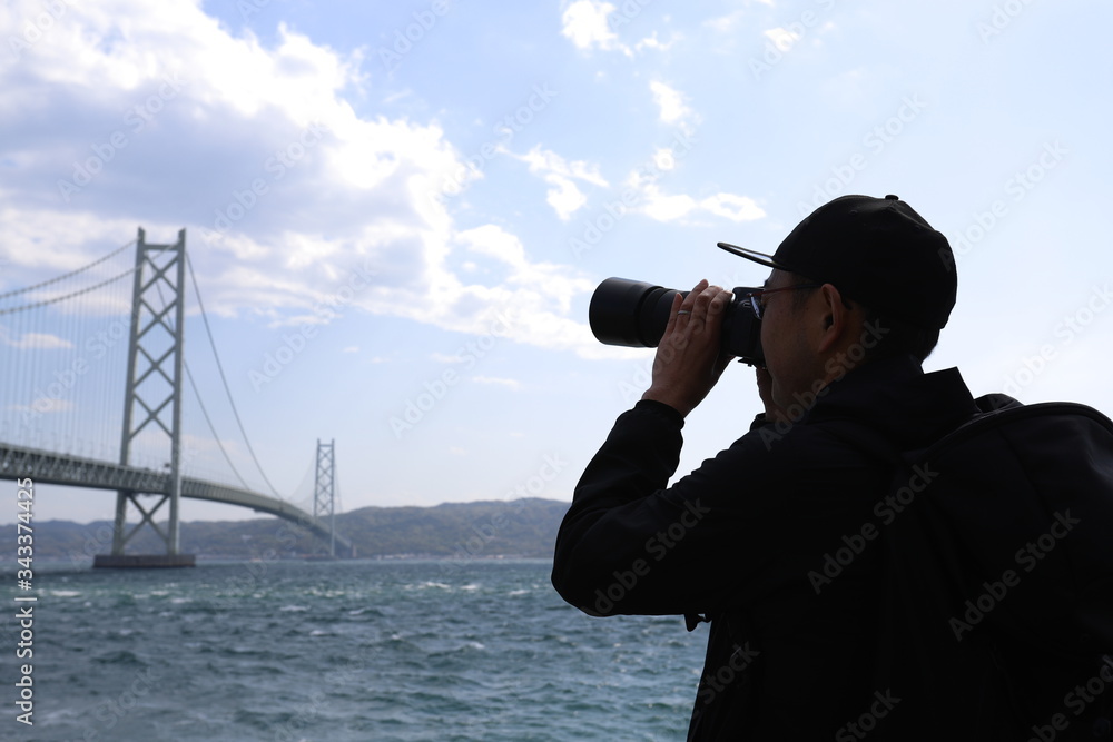 Obraz premium 大きな吊り橋を撮影する男性