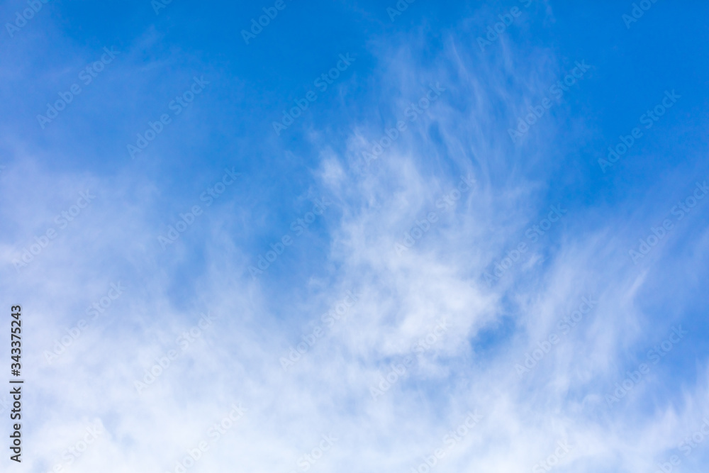 Obraz premium White clouds on a blue sky as background