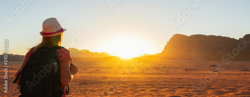 Woman enjoying the beautiful sunset in the Wadi Rum desert in Jordan. Banner.