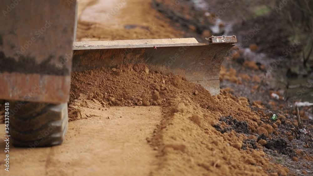 Excavator aligns the edges of the road shifting dirt. Preparation for work. Place for border Excavator aligns the edges of the road shifting dirt. Preparation for work. Place for border