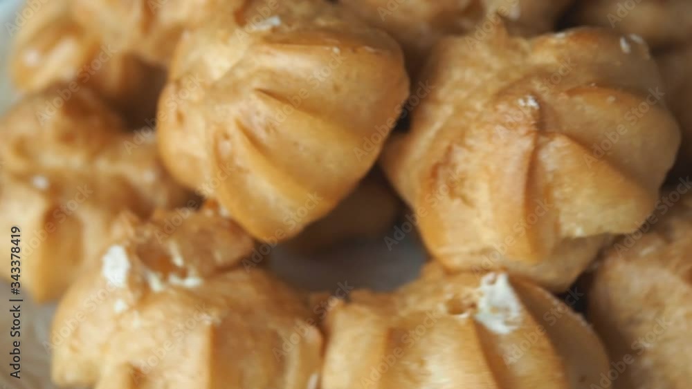 Profiteroles with custard cakes rotate. Close up.