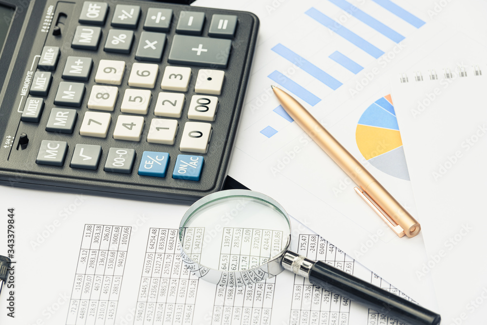 Business financial documents, office calculator and pen on the table. Numbers and graphs Business financial documents, office calculator and pen on the table. Numbers and graphs