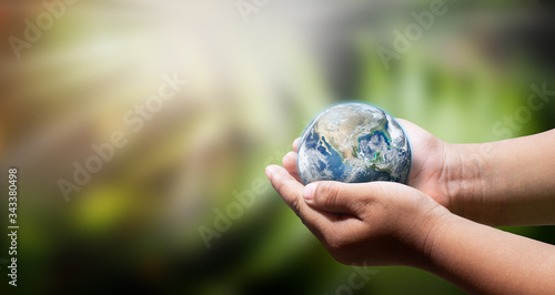 Earth globe blue or world in baby hands on sun fair light. A World environment day.Elements of this image furnished by NASA.