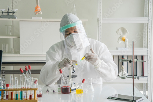 Photography The doctor wore germicidal clothing PPE, wear a face mask, and and face shield  put a test tube on the patient's blood