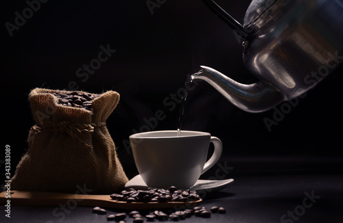 The big wood spoon, glass of coffe and coffee beans with black background