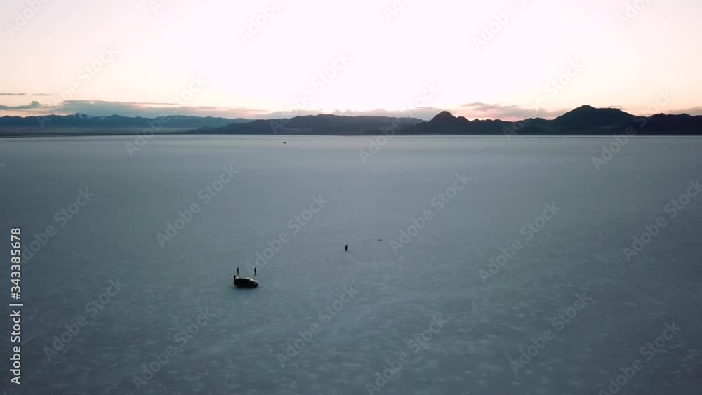 Aerial circling view of tourists in salty desert of Bonneville at dusk. Utah, USA Aerial circling view of tourists in salty desert of Bonneville at dusk. Utah, USA