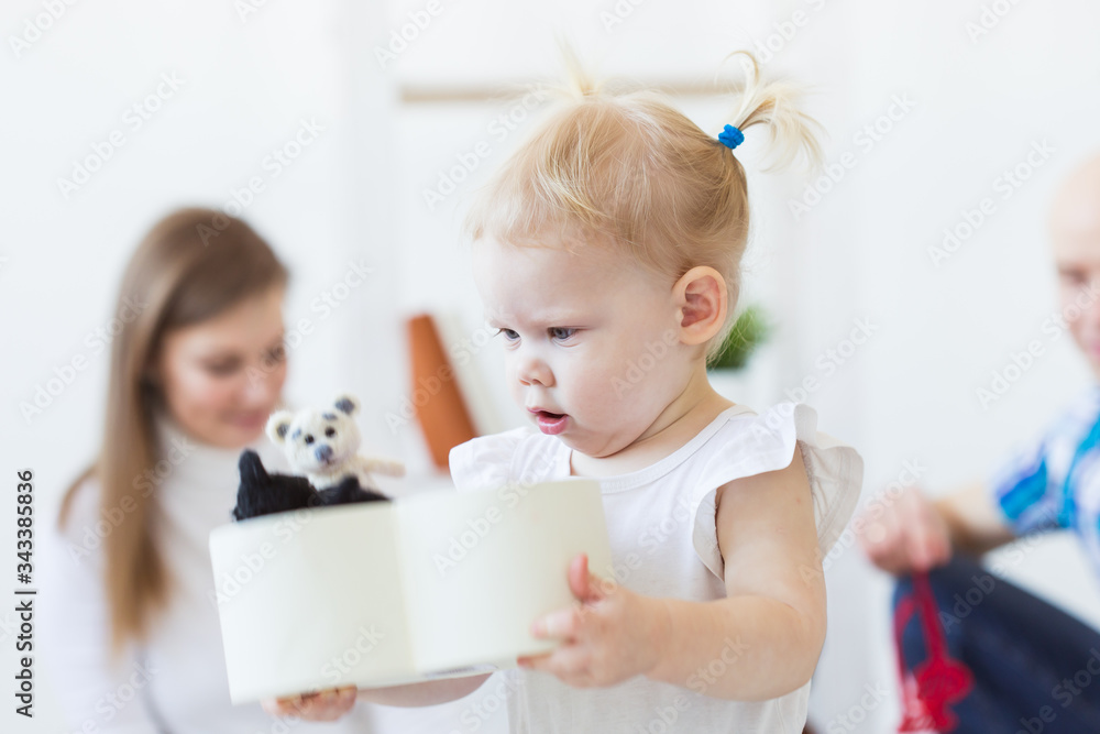 Funny baby toddler girl playing in living room. Children and family concept. Funny baby toddler girl playing in living room. Children and family concept.