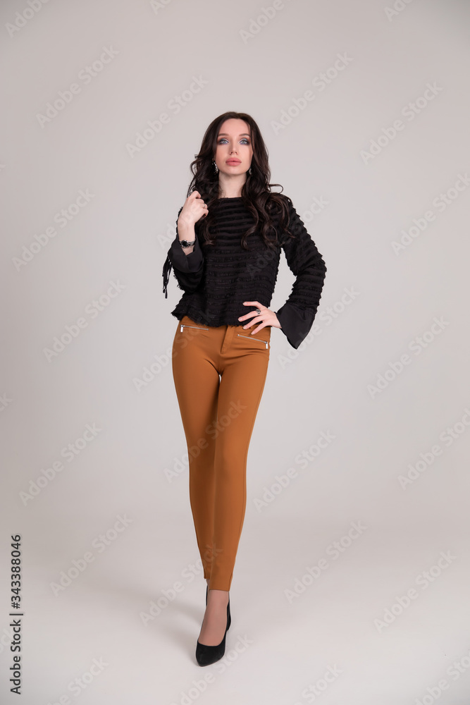 Beautiful young girl smiles and poses on brown beige background. Copy space Beautiful young girl smiles and poses on brown beige background. Copy space