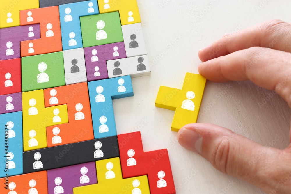 business concept image of tangram puzzle blocks with people icons over wooden table ,human resources and management concept business concept image of tangram puzzle blocks with people icons over wooden table ,human resources and management concept