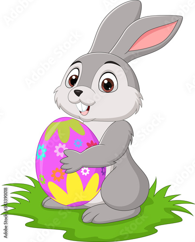 Cartoon little rabbit holding easter egg in the grass