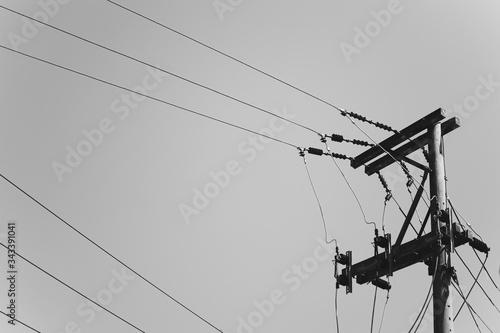 Old electric pylon with power lines, gray background