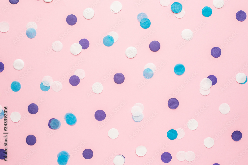 Blue, white and lilac confetti on pink color paper background minimal style