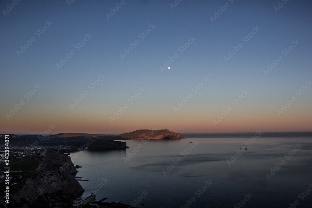 colorful sunset and moon over the coast in Sudak Crimea