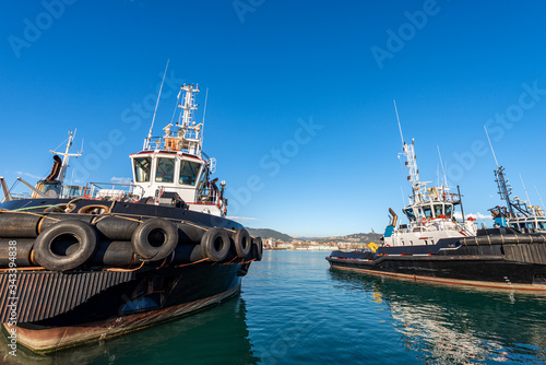 Tugboats moored in the port of the Gulf of La Spezia on a clear blue sky. Liguria, Italy, Europe