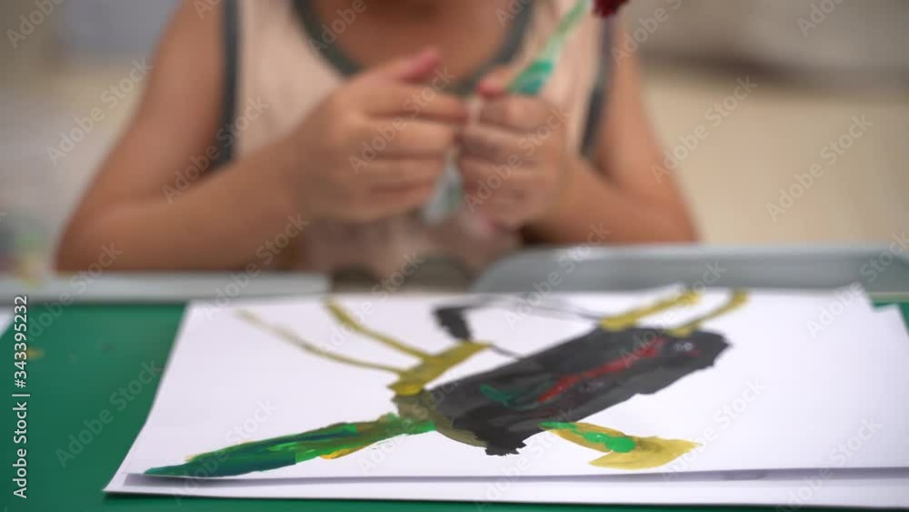 Asian boy about 4 years old painting picture with watercolor and toothbrush as study at home Asian boy about 4 years old painting picture with watercolor and toothbrush as study at home