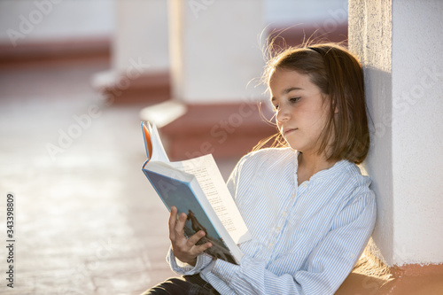 Relaxed girl reading a book sitting on the rooftop