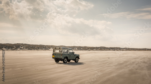 Terschelling, Holland - 8 march 2020: Land Rover Defender on North Sea beach. The iconic and legendary Land Rover Defender was issued in 1983.