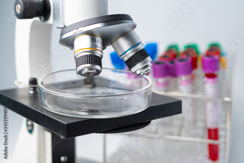 Microscope with test tube of micro biological for scientist biochemist or microbiologist working research in laboratory.