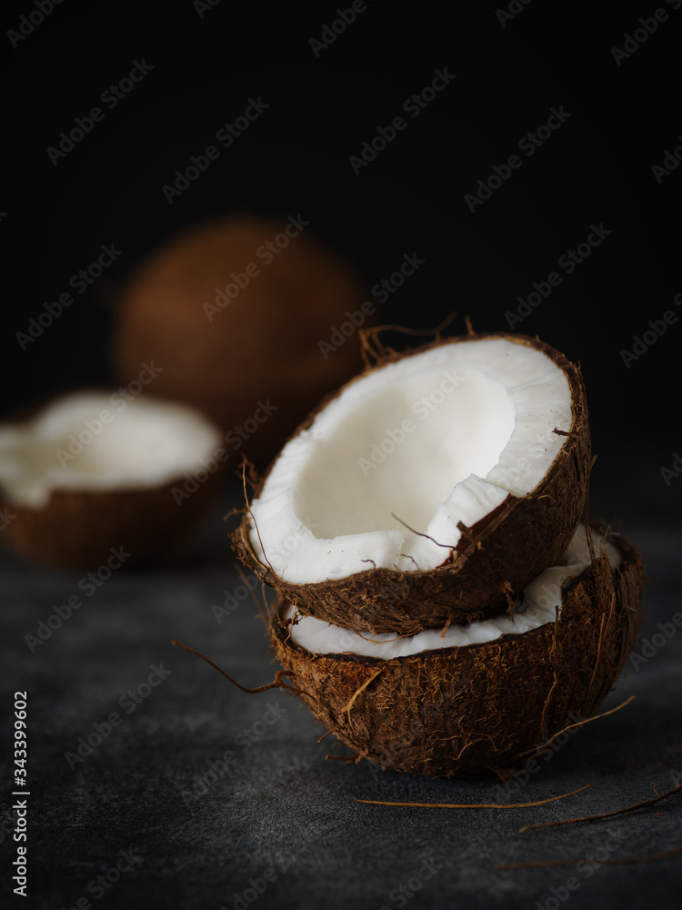 Coconut halves on a dark background.