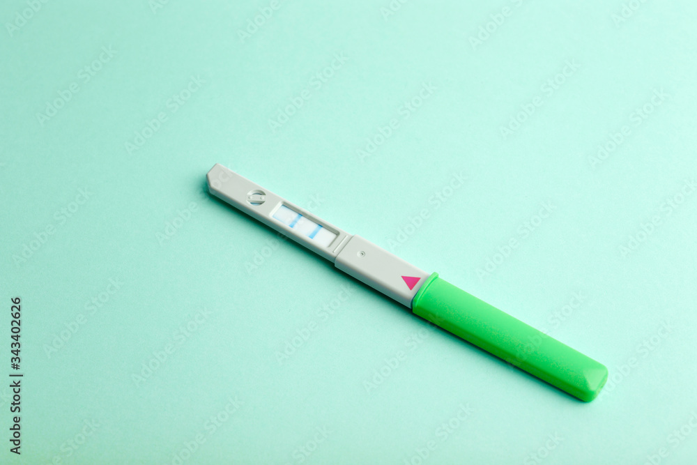 Pregnancy test on a blank colored background. Pregnancy, conception, and women's health. Birth of a baby concept Pregnancy test on a blank colored background. Pregnancy, conception, and women's health. Birth of a baby concept