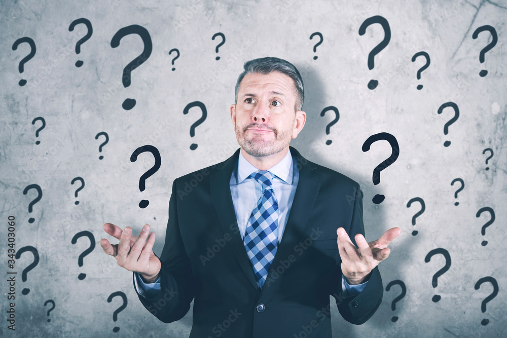 Confused businessman standing with question mark Confused businessman standing with question mark