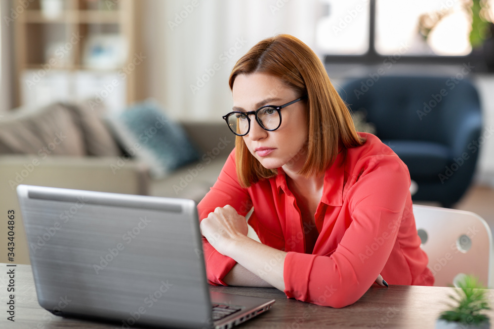 remote job, technology and people concept - bored or tired young woman in glasses with laptop computer working at home office remote job, technology and people concept - bored or tired young woman in glasses with laptop computer working at home office