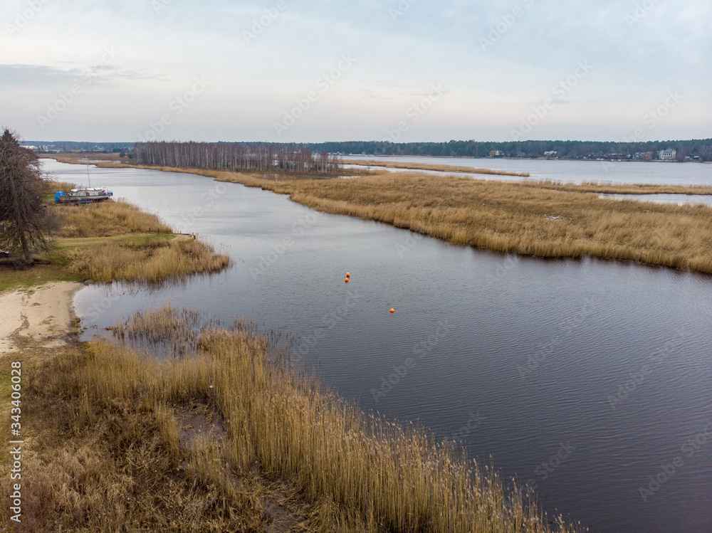 Beautiful riverside areal view of river Lielupe flowing near pine forest strees on both coast lines.