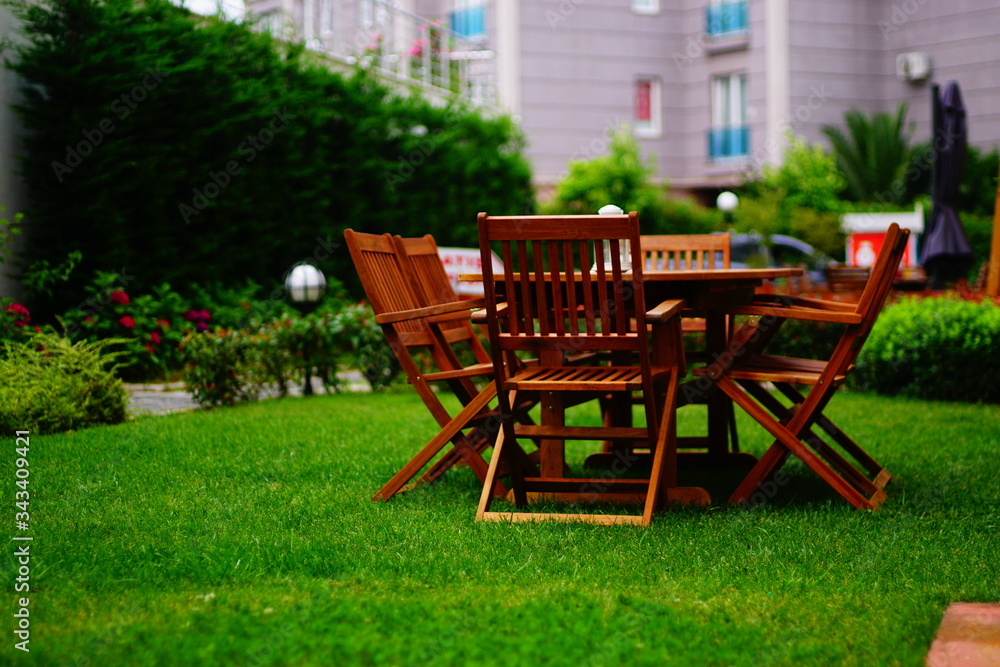 wooden garden table and chairs. Wooden dining table and wooden chairs on the grass.