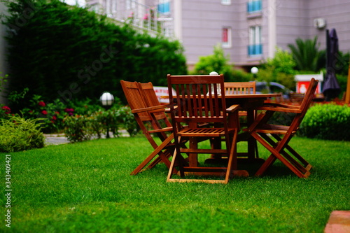 wooden garden table and chairs. Wooden dining table and wooden chairs on the grass.