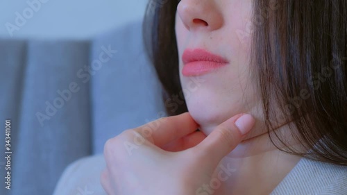 Closeup of woman's secong chin, problems with excess weight. Woman is touching her chin to demostrate her cosmetic problem. Examining double chin, need facial line correction.