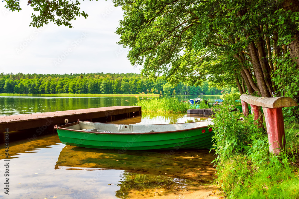 Calm relaxing nature scene. Small boat on the shore on the lake.