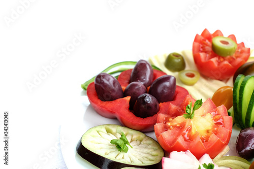 Plate of vegetarian breakfast food with cucumber, tomato, green olives, potato spiral, yellow cheese and red bell pepper
