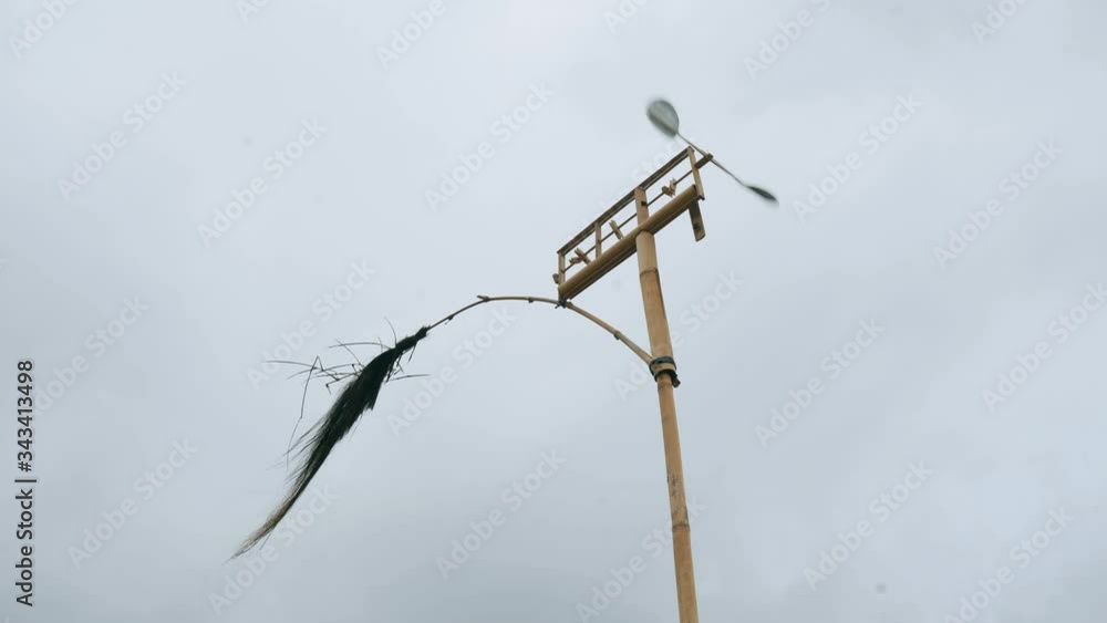 Balinese wind object in the cloudy sky. It’s turning under strong wind. Weather measurement Balinese wind object in the cloudy sky. It’s turning under strong wind. Weather measurement