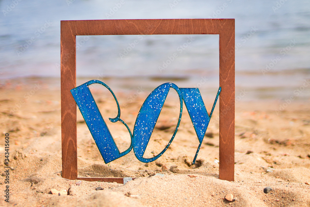 wooden inscription boy on a blue water background wooden inscription boy on a blue water background