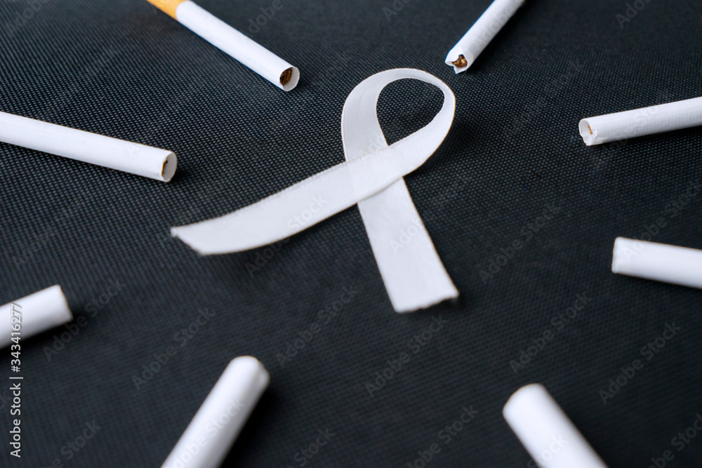 White ribbon and cigarette on black background White ribbon and cigarette on black background