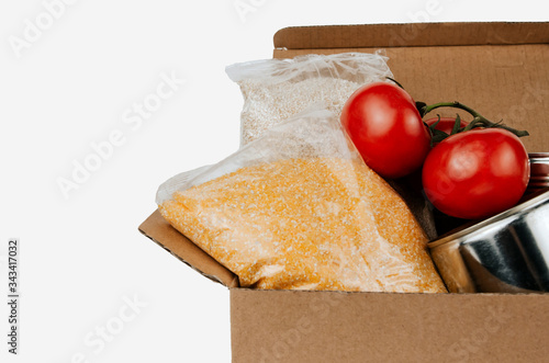 Box with products. Food donation. Vegetables, cereals and canned goods in a cardboard box isolated.