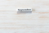 Wooden block of calendar with month September on wood background