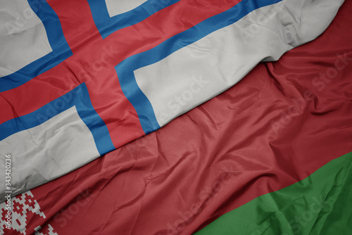 waving colorful flag of belarus and national flag of faroe islands.