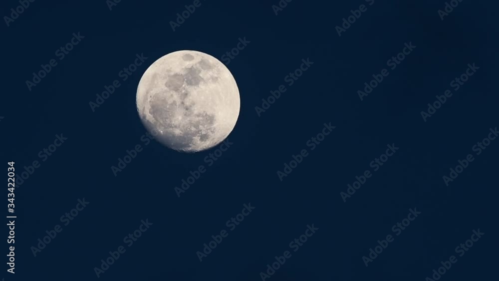 Bright white almost full moon view, shining on a clear blue night sky Bright white almost full moon view, shining on a clear blue night sky