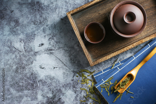 clay tea set and tea book on dark cement background 